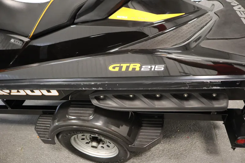 Slide: The Image of 2012 Sea-Doo GTR 215 jet ski on trailer, black with yellow accents. - 20