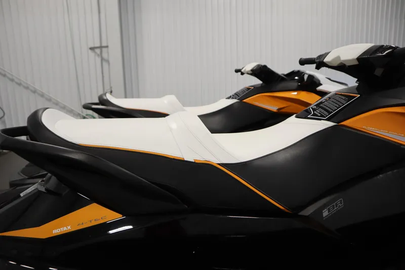 Slide: The Image of 2012 Sea-Doo GTR 215 jet skis with sleek black and orange design in storage. - 30