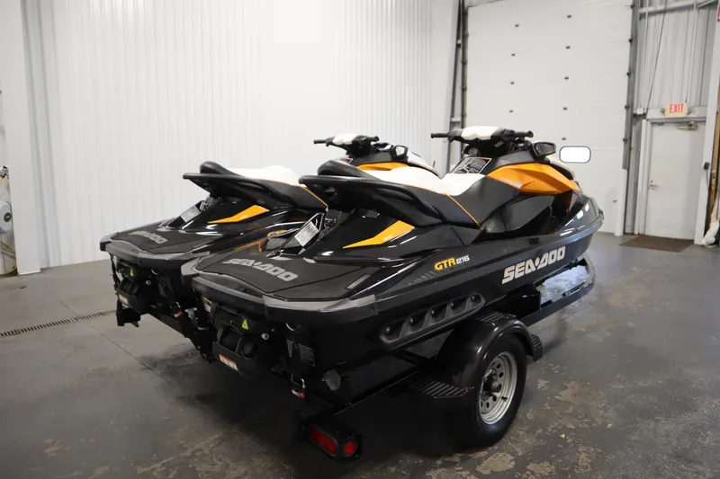 Slide: The Image of 2012 Sea-Doo GTR 215 jet skis on trailer in indoor garage setting. - 5