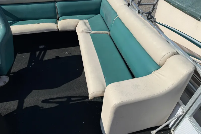 Slide: The Image of 1994 Sun Quest Sea Hunt boat interior with teal and white seating arrangement. - 10