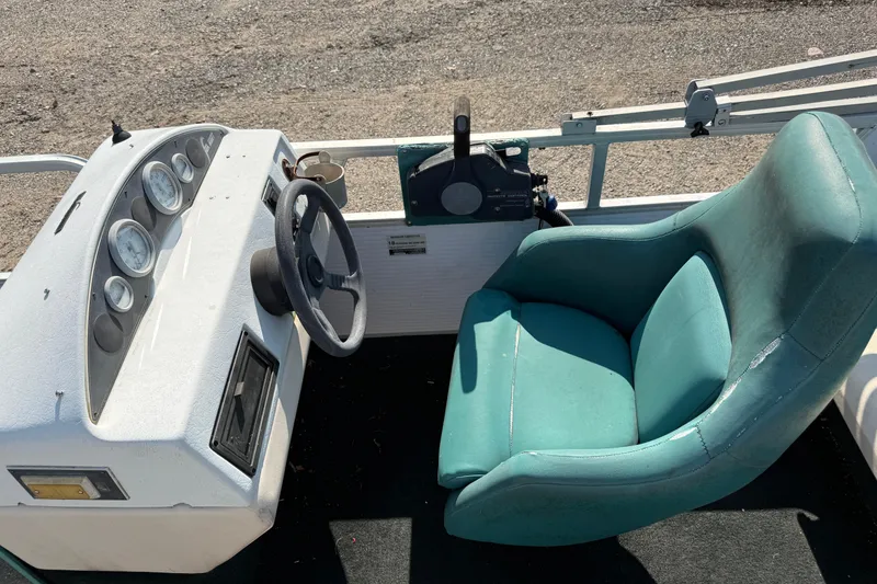Slide: The Image of 1994 Sun Quest Sea Hunt boat dashboard with teal captain's chair and steering wheel. - 11
