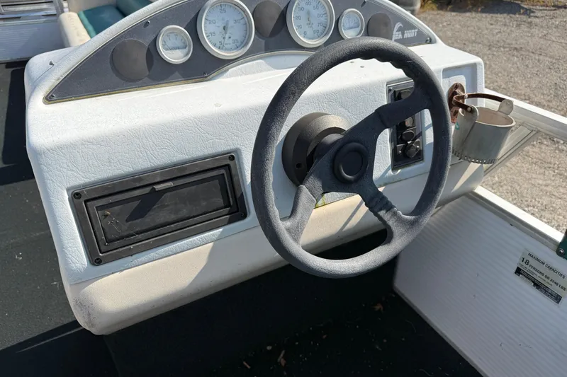 Slide: The Image of 1994 Sun Quest Sea Hunt boat dashboard with steering wheel and gauges. - 12