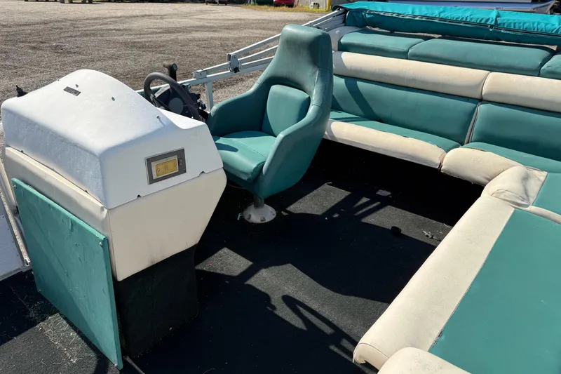 Slide: The Image of 1994 Sun Quest Sea Hunt boat interior with teal seating and steering console. - 8