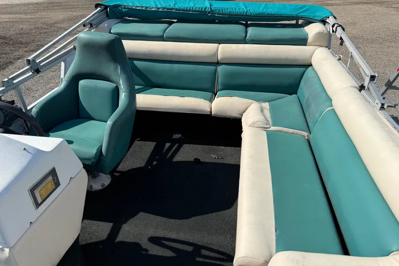 Slide: The Image of 1994 Sun Quest Sea Hunt boat interior with teal and white seating. - 9