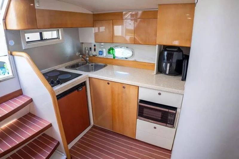 Slide: The Image of Compact kitchen in 1999 Cranchi Mediterranee 41 yacht with modern appliances and wooden cabinetry. - 14