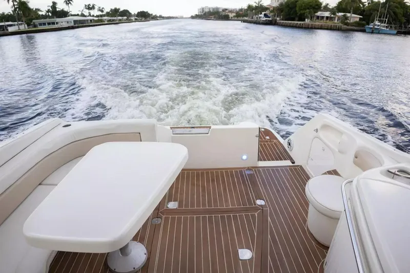 Slide: The Image of 1999 Cranchi Mediterranee 41 yacht deck with table, cruising on a scenic waterway. - 6