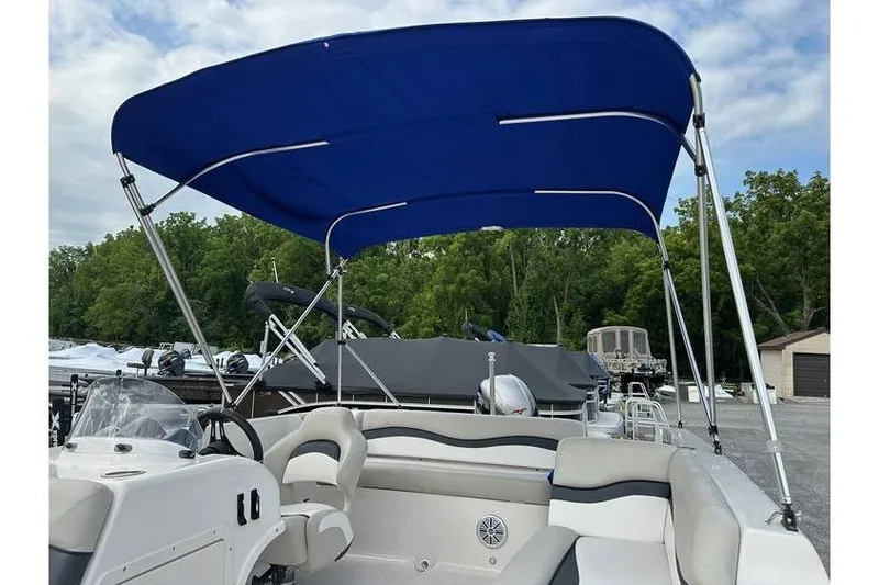 Slide: The Image of 2021 Starcraft 1915 OB Limited boat with blue canopy, parked outdoors. - 27