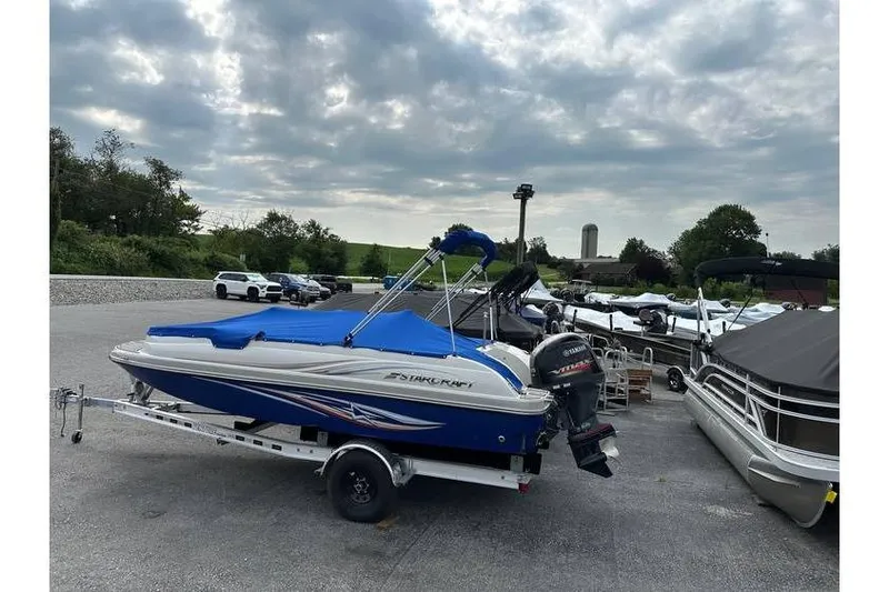 Slide: The Image of 2021 Starcraft 1915 OB Limited boat on trailer, parked outdoors under cloudy sky. - 37