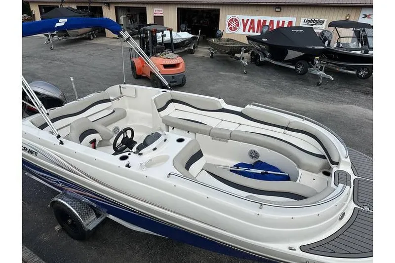 Slide: The Image of 2021 Starcraft 1915 OB Limited boat with spacious seating, parked at a dealership. - 7