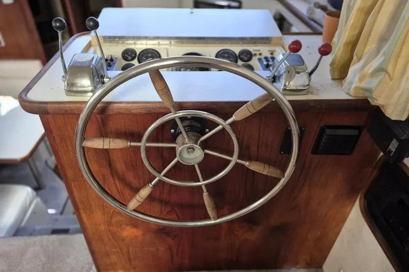 Slide: The Image of 1991 Carver 36 Aft Cabin Motor Yacht helm with wooden steering wheel and controls. - 19