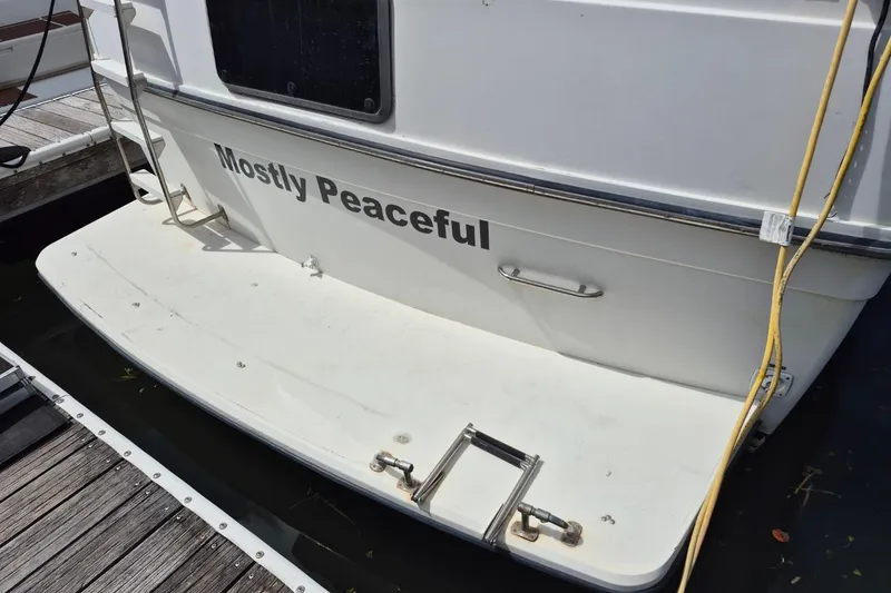 Slide: The Image of 1991 Carver 36 Aft Cabin Motor Yacht named "Mostly Peaceful" docked at marina. - 2