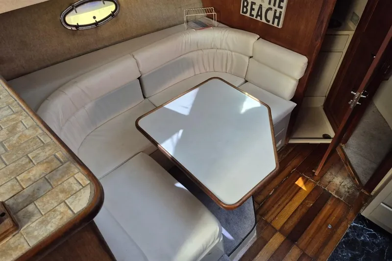 Slide: The Image of 1991 Carver 36 Aft Cabin Motor Yacht interior with cozy dining area and wooden flooring. - 23