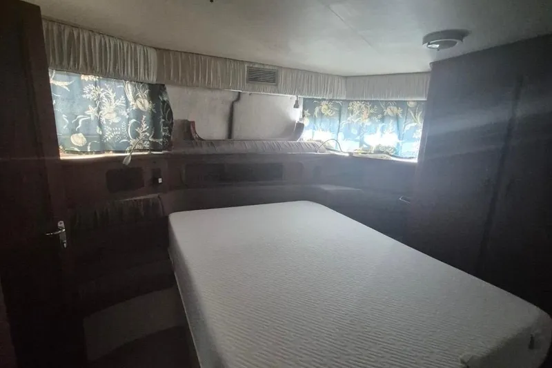 Slide: The Image of Interior of 1991 Carver 36 Aft Cabin Motor Yacht with bed and floral curtains. - 33