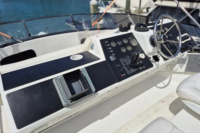 Slide: The Image of 1991 Carver 36 Aft Cabin Motor Yacht helm with steering wheel and control panel. - 6