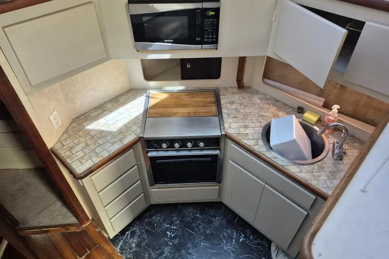 Slide: The Image of 1991 Carver 36 Aft Cabin Motor Yacht kitchen with stove, microwave, and sink. - 24