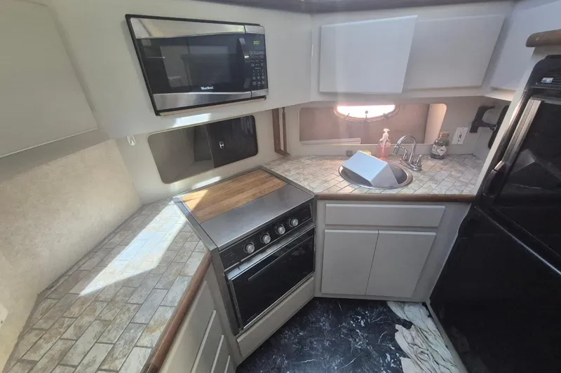Slide: The Image of 1991 Carver 36 Aft Cabin Motor Yacht kitchen with microwave, stove, and sink. - 25
