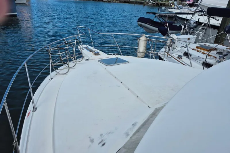 Slide: The Image of 1991 Carver 36 Aft Cabin Motor Yacht docked, showcasing spacious deck and railing. - 4