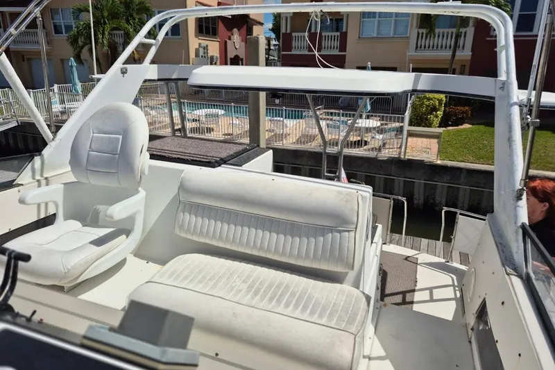 Slide: The Image of 1991 Carver 36 Aft Cabin Motor Yacht interior with white seating and outdoor view. - 8