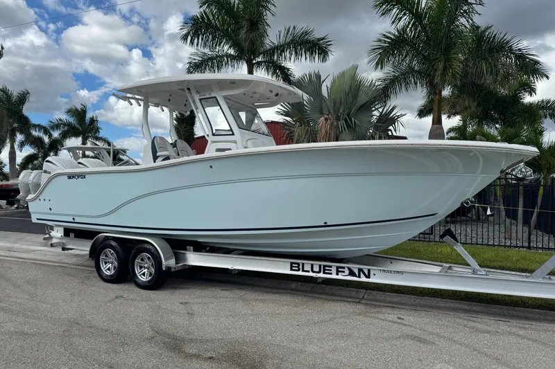 The Image of 2025 Sea Fox 288 Commander boat on trailer, surrounded by palm trees. - 1