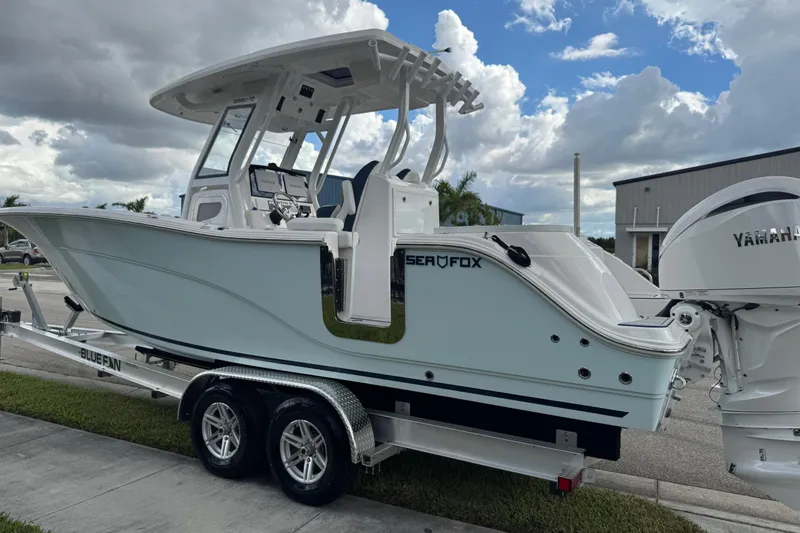 Slide: The Image of 2025 Sea Fox 288 Commander boat on trailer, featuring Yamaha engines, under cloudy sky. - 21