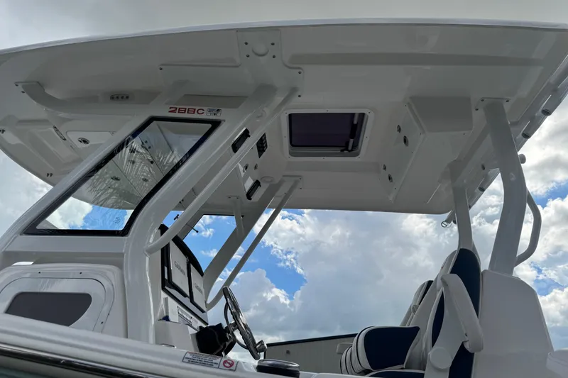 Slide: The Image of 2025 Sea Fox 288 Commander boat interior with helm and seating under cloudy sky. - 24