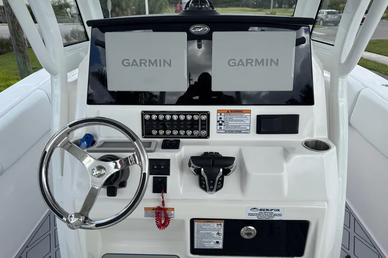 Slide: The Image of 2025 Sea Fox 288 Commander dashboard with dual Garmin displays and steering wheel. - 26