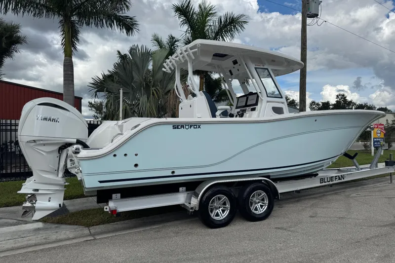 Slide: The Image of 2025 Sea Fox 288 Commander boat on trailer, parked near palm trees. - 3