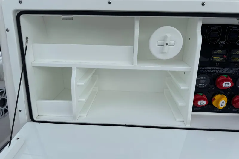 Slide: The Image of 2025 Sea Fox 288 Commander storage compartment with control panel and organized shelving. - 34