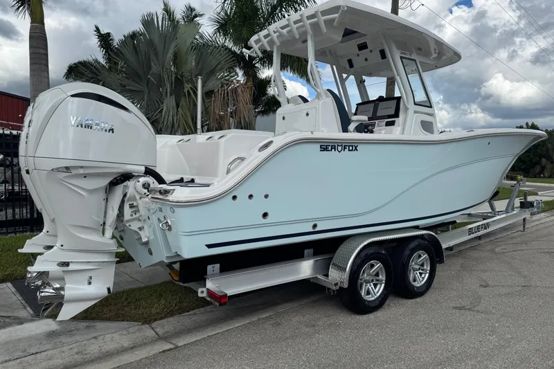 Slide: The Image of 2025 Sea Fox 288 Commander boat on trailer, featuring Yamaha engine, parked near palm trees. - 4