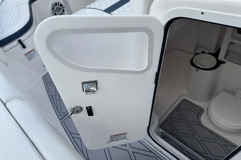 Slide: The Image of 2025 Sea Fox 288 Commander boat interior with open door revealing compact restroom. - 87