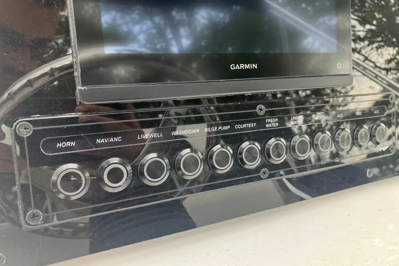 Slide: The Image of Control panel of 2026 Tidewater 1910 Bay Max boat with Garmin display and various switches. - 17