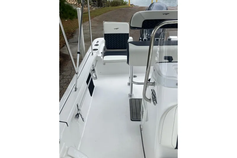 Slide: The Image of 2026 Tidewater 1910 Bay Max boat interior with seating and console, docked by a lakeside path. - 28