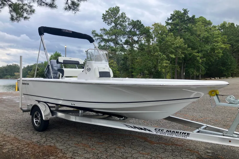 Slide: The Image of 2026 Tidewater 1910 Bay Max boat on trailer, parked near a scenic lake. - 3