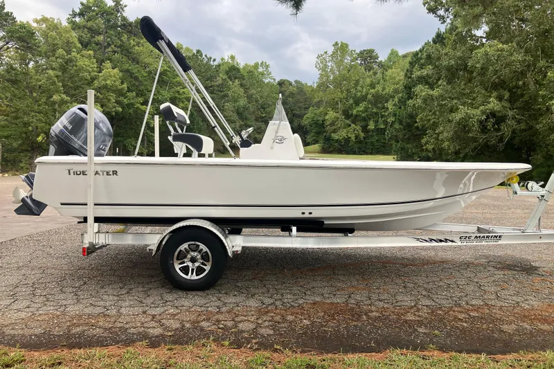Slide: The Image of 2026 Tidewater 1910 Bay Max boat on trailer, parked outdoors with trees in background. - 4