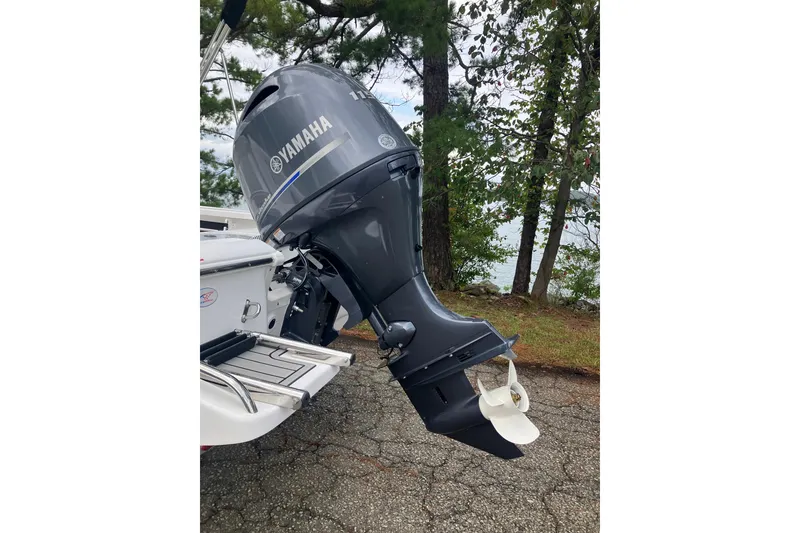 Slide: The Image of Tidewater 1910 Bay Max 2026 with Yamaha outboard motor, parked near a lake. - 8