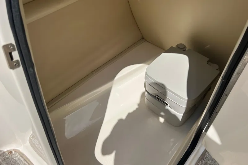 Slide: The Image of Portable toilet inside 2002 Chaparral Sunesta 243 boat compartment. - 11