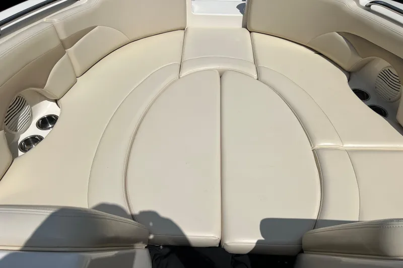 Slide: The Image of 2002 Chaparral Sunesta 243 boat interior with beige seating and cup holders. - 12