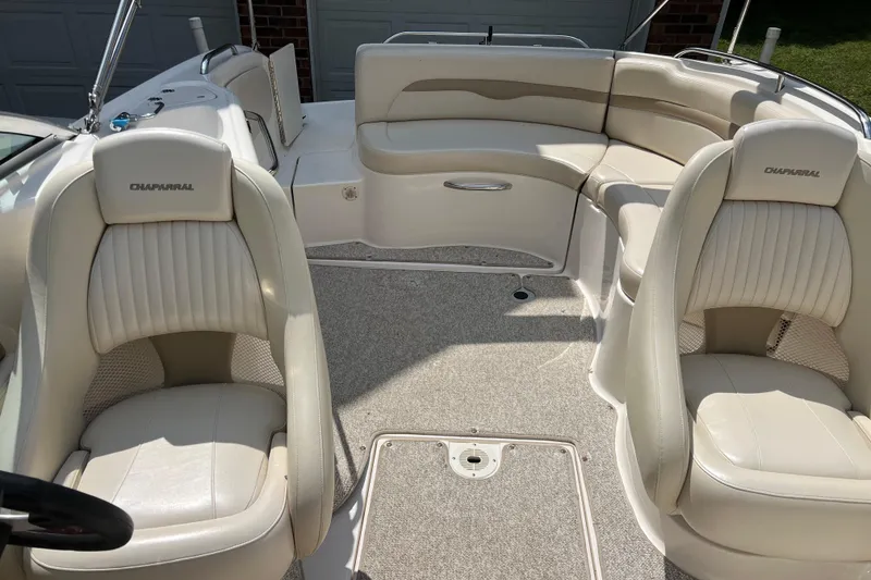 Slide: The Image of 2002 Chaparral Sunesta 243 boat interior with beige seating and carpeted floor. - 13