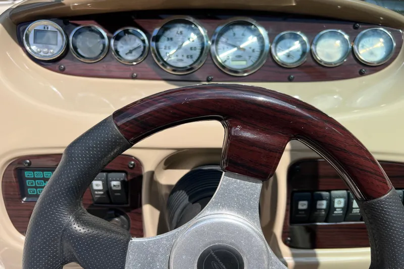 Slide: The Image of Steering wheel and dashboard of 2002 Chaparral Sunesta 243 boat with gauges and controls. - 15