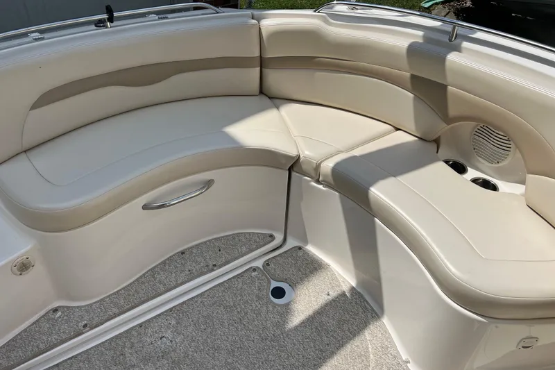 Slide: The Image of 2002 Chaparral Sunesta 243 boat interior with beige seating and cup holders. - 6