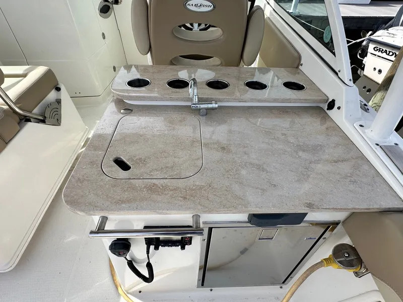 Slide: The Image of 2018 Sailfish 275DC boat interior with beige countertop, sink, and cup holders. - 20