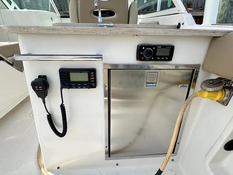 Slide: The Image of 2018 Sailfish 275DC boat console with radio, control panel, and stainless steel storage. - 21