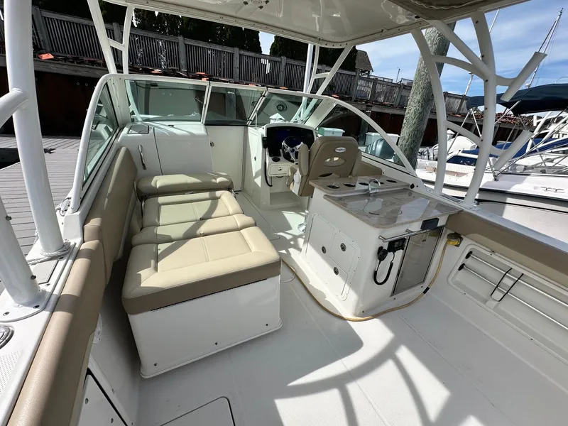Slide: The Image of 2018 Sailfish 275DC boat interior with seating and helm station, docked at marina. - 28