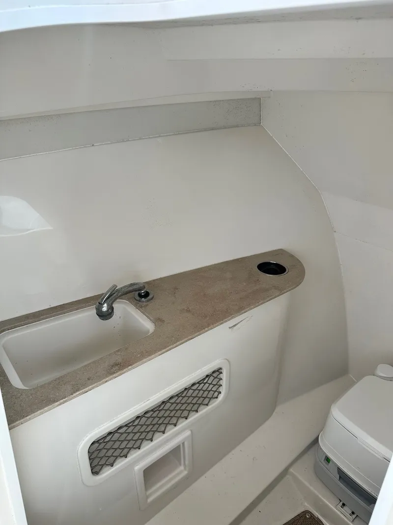 Slide: The Image of 2018 Sailfish 275DC boat interior with sink and compact toilet. - 31