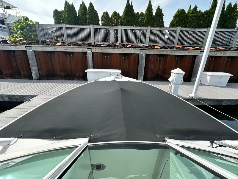 Slide: The Image of 2018 Sailfish 275DC boat docked, covered with black canvas, wooden dock in background. - 34