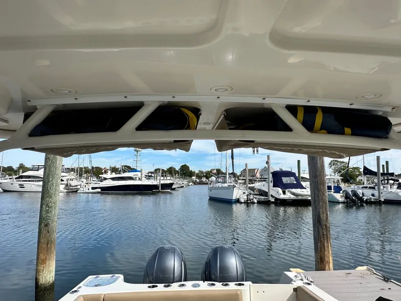 Slide: The Image of 2018 Sailfish 275DC boat docked at marina with other vessels in background. - 35