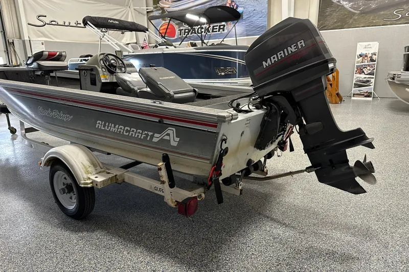 Slide: The Image of 1994 Alumacraft Classic 165 CS boat with Mariner outboard motor in showroom. - 2