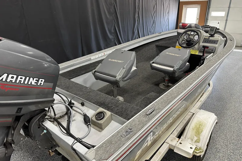 Slide: The Image of 1994 Alumacraft Classic 165 CS boat interior with three seats and steering console. - 5