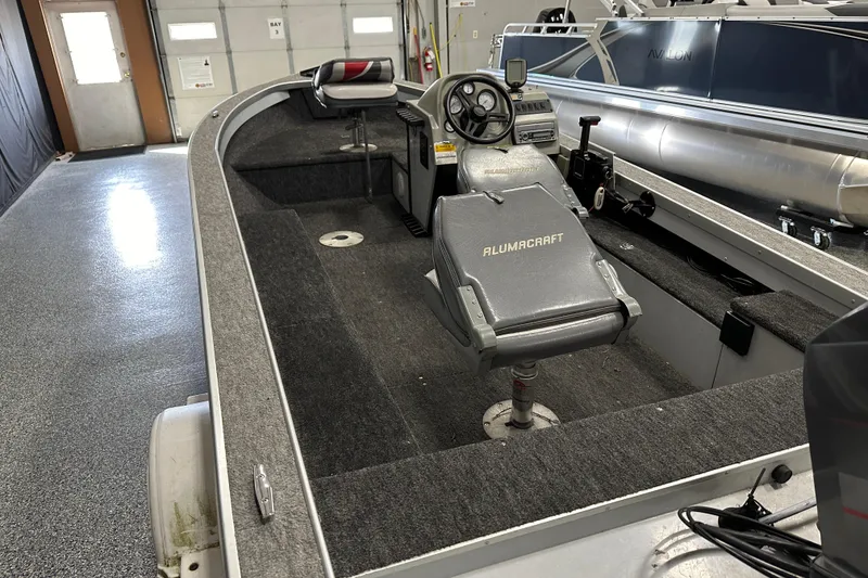 Slide: The Image of 1994 Alumacraft Classic 165 CS boat interior with seating and control panel. - 6