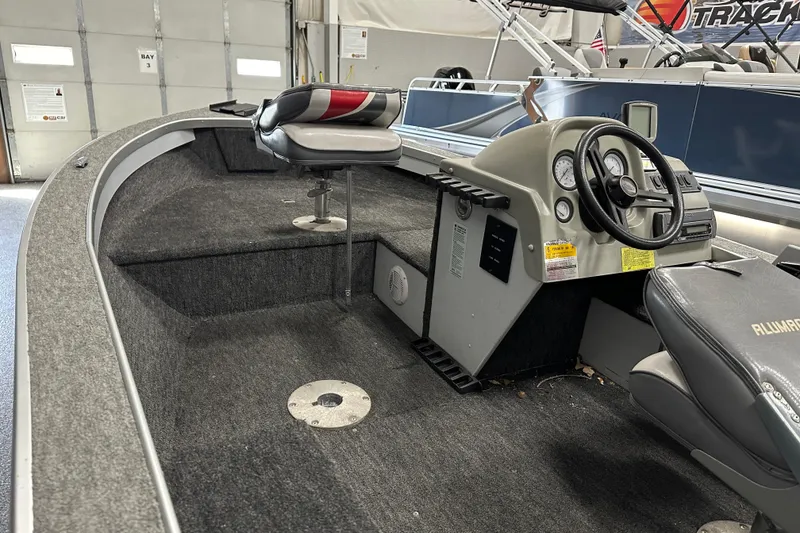 Slide: The Image of 1994 Alumacraft Classic 165 CS boat interior with seating and steering console. - 7